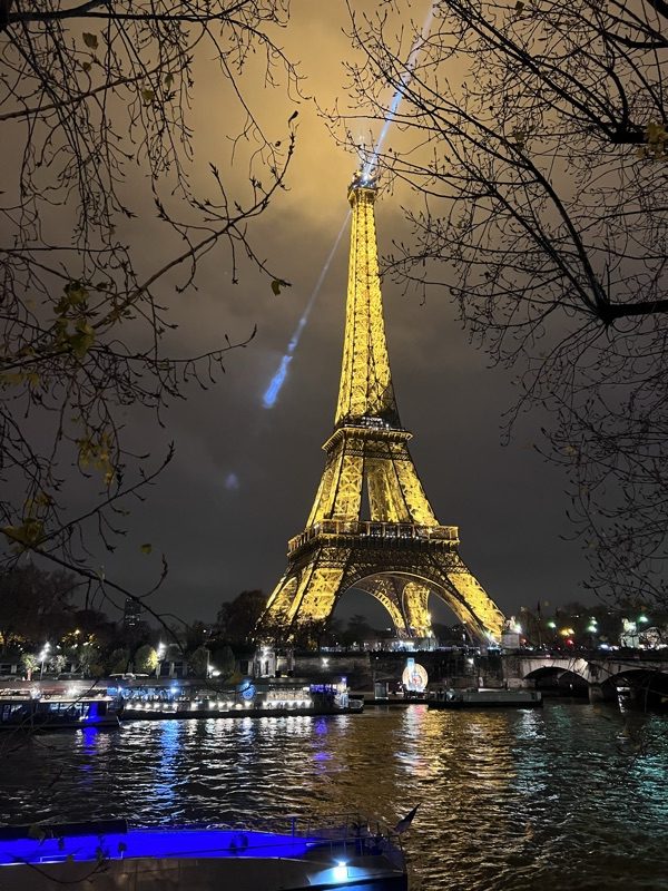 The Eiffel Tower at night, seen from across the Seine
